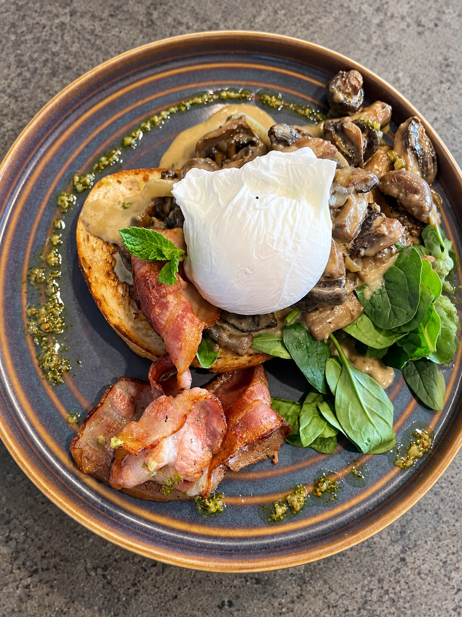 Poached eggs, mushrooms, bacon and greens on an On Levers Cafe breakfast plate
