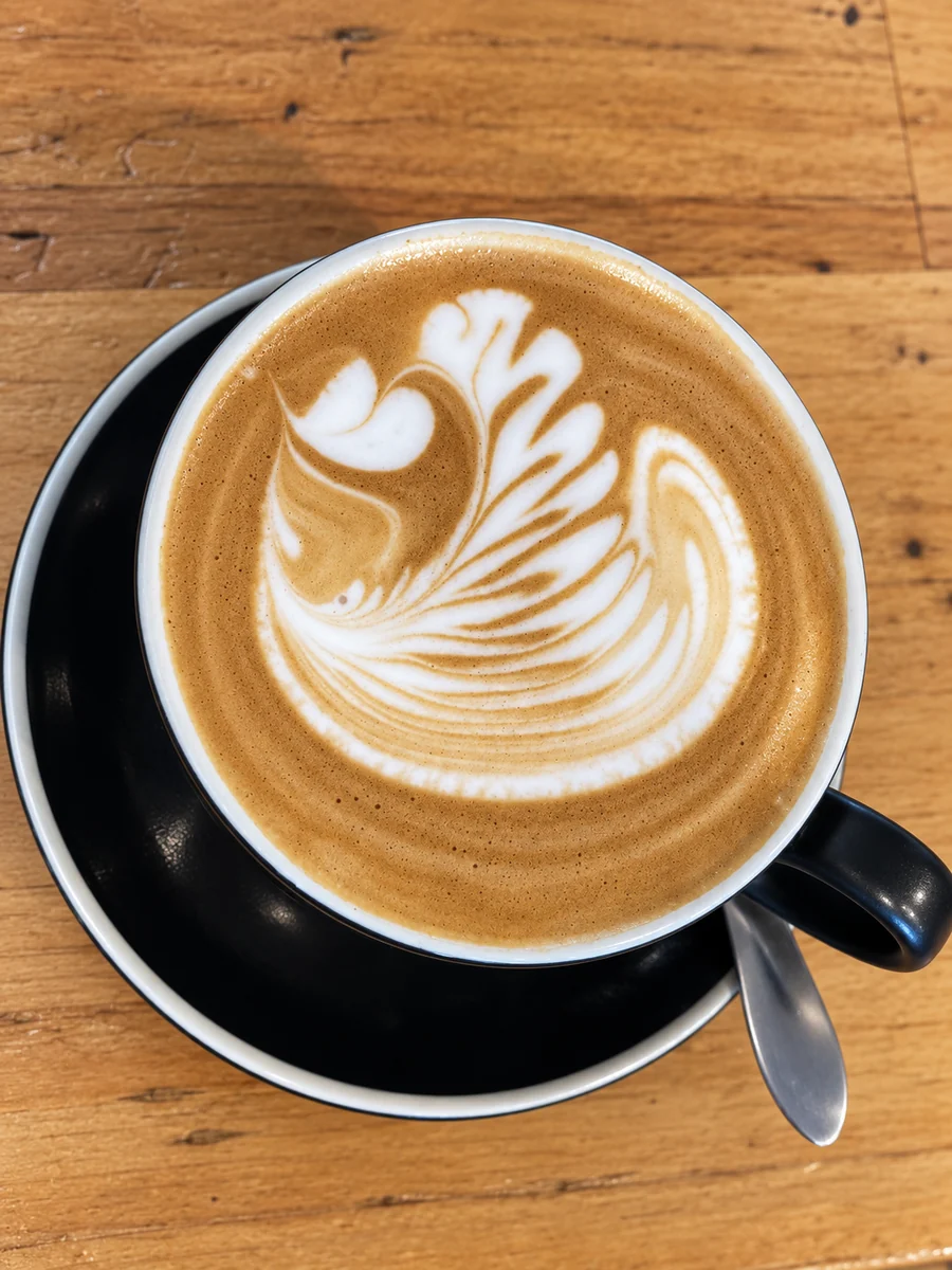 Fresh latte art in a black cup at On Levers Cafe